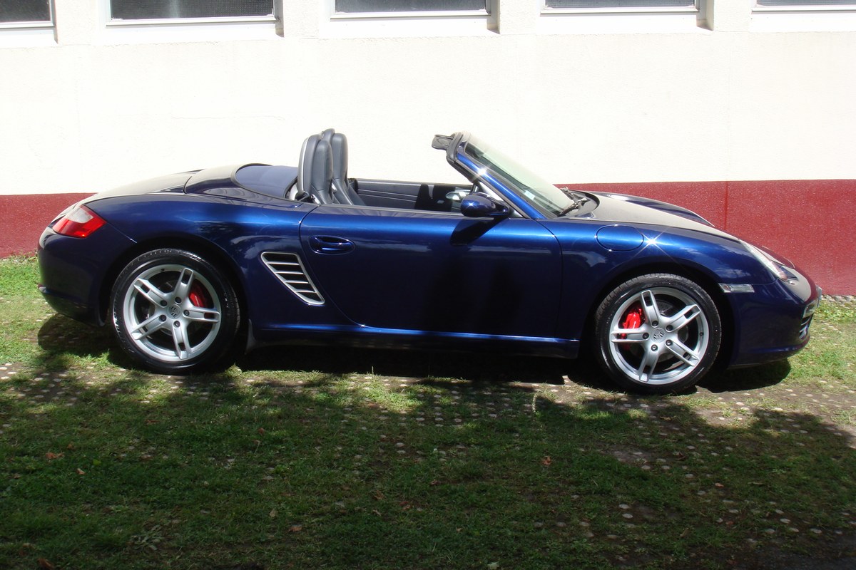 Porsche Boxster 987 S bleu nuit de profil, capote ouverte, jantes 5 branches